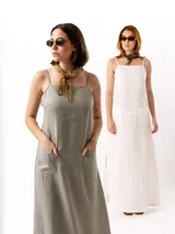 Vestido largo de lino en color beige, con escote recto, tirantes finos ajustables, cierre lateral y bolsillos frontales tipo parche.
