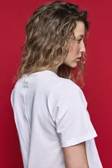 Remera de algodón color blanco con diseño de tablas verticales en el frente que aportan movimiento y estructura.
