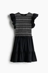 Vestido corto negro de popelina de algodón, con cuerpo texturado a rayas blancas y negras, escote redondo, mangas circulares con volados y falda escalonada de popelina lisa.