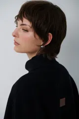 Poncho de tejido de punto color caramelo con cuello alto y diseño holgado sin mangas.