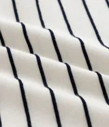 Remera de corte regular confeccionada en tejido de algodón y poliéster, con cuello redondo y mangas cortas. Presenta un diseño de rayas horizontales finas en relieve.