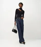 Blusa de punto acanalado color lila, con cuello alto, mangas largas y abertura en el hombro.