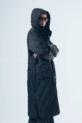 Campera acolchada de largo midi en color negro, con diseño de matelassé romboidal, cierre frontal con botones y capucha desmontable.