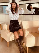 Minifalda con estampado geométrico en tonos amarillo, negro y gris, con detalle de plumas en el ruedo.