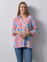 Camisa estampada con hojas en tonos rosa, azul y naranja. Cuello con solapa y abertura central con botones. Delantera con bolsillos aplicados. Manga 3/4 con lazo.