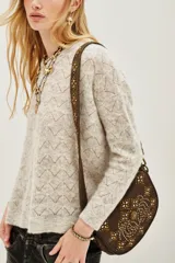 Sweater de punto con diseño calado geométrico, cuello redondo y mangas largas. Confeccionado en una mezcla de lana y alpaca, presenta una textura suave y ligera.