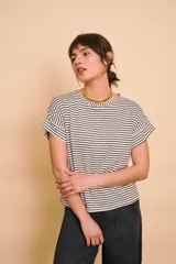 Remera de corte holgado, con diseño a rayas horizontales en color crudo y azul marino, cuello redondo y mangas cortas con vuelta.