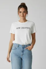 Remera de algodón de manga corta y cuello redondo, con estampado frontal con la frase 'NEW CHAPTER' en tipografía negra.