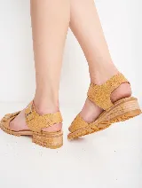 Sandalias de cuero color ocre con doble tira sobre el empeine y hebillas metálicas plateadas. Suela de goma con plataforma baja y detalle de costuras.