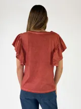 Remera de algodón color blanco, con cuello en V y mangas cortas con volados.