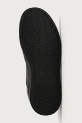 Zapatillas deportivas de estilo retro, color negro, con diseño superior de paneles combinados, cordones al tono y suela gruesa con volumen.