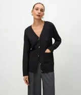 Cardigan de punto color negro con escote en V, cierre frontal con botones, mangas largas con puños acanalados y bolsillos frontales funcionales.