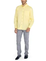 Camisa de manga larga de algodón orgánico color amarillo, con cuello abotonado, cierre frontal de botones, bolsillo en el pecho con logo bordado y mangas ajustables.