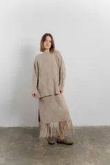 Sweater color arena de tejido geométrico con calce relajado, hombros caídos y terminaciones suaves.