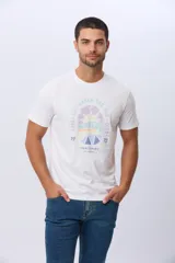 Remera de algodón blanca con cuello redondo y manga corta. Presenta un estampado frontal con diseño gráfico estilo retro que incluye motivos de sol, mar y montañas, junto con la inscripción 'Life Under The Sun Club'.