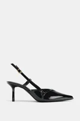 Zapato de tacón fino con acabado en punta, confeccionado en material sintético brillante. Presenta un diseño de tiras cruzadas en el empeine con detalles de hebillas metálicas y una tira trasera ajustable con cierre de hebilla.