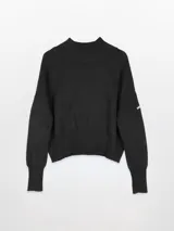 Polera negra de punto con cuello alto, hombros caídos y mangas largas. Puños, cintura y cuello en rib.