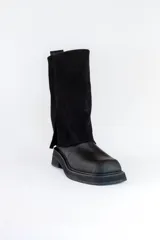 Bota de cuero negra con caña alta y detalle volcado en la parte superior. Taco bajo y puntera redondeada.