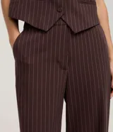 Pantalón sastrero de corte recto, confeccionado en crepé con diseño de rayas verticales. Presenta un estilo clásico y elegante con una caída fluida.