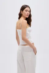 Musculosa de viscosa al cuerpo con cuello redondo y breteles finos decorados con cuentas.
