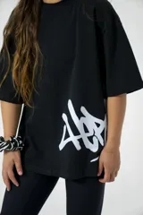 Remera oversize negra de algodón elastizado con estampado blanco en el frente.