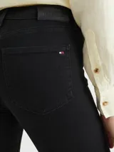 Pantalón de jean negro, corte skinny, con cierre de botón y cremallera, cinco bolsillos y parche de Tommy Hilfiger en la parte posterior de la cintura.