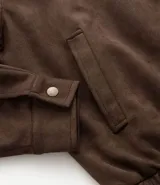 Campera masculina de estilo casual con cuello inglés, cierre frontal por cremallera, bolsillos laterales y ajuste elástico en el bajo. Presenta detalles de recortes en la parte superior delantera.