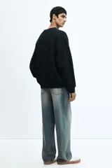 Jean de cinco bolsillos en denim de algodón rígido, color azul claro con efecto desgastado. Modelo de corte holgado de cadera a bajo con piernas redondeadas extraamplias y pliegues al tobillo. Cintura clásica con cierre y tiro bajo.