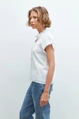 Camisa blanca de manga corta con cuello mao y detalle de punto smock.