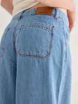 Pantalón de tiro medio alto, color beige, con bolsillos delanteros y traseros. Presenta detalles de atraques y triples costuras en color amarillo. Confeccionado en una mezcla de lino, algodón y viscosa.