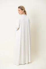 Vestido camisero largo color marfil, de satén de seda, con cuello camisero, mangas largas y bolsillos laterales.