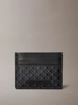 Tarjetero Calvin Klein de diseño compacto con estampado de monograma integral en tonos oscuros y ranuras para tarjetas. Incluye un parche con el logo de la marca en la parte frontal.