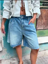 Bermuda de jean azul claro, corte a la rodilla, con bolsillos delanteros y traseros.