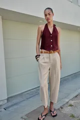 Pantalón tobillero azul marino de tiro medio, con pinzas delanteras, bolsillos frontales, falsos bolsillos con solapa en la espalda y cierre frontal con cremallera, botón y gancho. Incluye cinturón de cuero sintético tostado con hebilla metálica dorada.