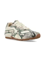 Sneaker Hush Puppies modelo Storm con diseño de imitación piel de serpiente en tonos beige, blanco y negro, con detalles de ribetes en color verde oscuro y suela de goma marrón.