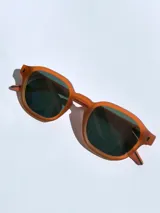 Lentes de sol con armazón de marco completo en color gris mate, con detalles decorativos en color rojo en las esquinas y patillas. Cuentan con cristales oscuros polarizados con protección UV 400.