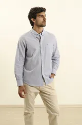Camisa sport de hombre a rayas verticales azules y blancas, de manga larga con cuello button-down y bolsillo en el pecho. Tejido 100% algodón con efecto cloqué.