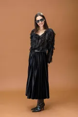 Camisa negra de tela semitransparente con volados frontales y en las mangas, escote en V y cierre frontal con botones.