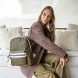 Mochila mediana color rosa, de nylon con detalles en símil cuero en el bolsillo frontal. Tiene asa de mano y correas regulables.