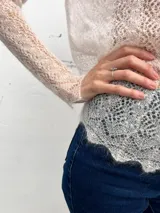 Sweater de punto calado confeccionado en 100% mohair italiano, con cuello redondo y mangas largas. Presenta una textura aireada y delicada con un diseño etéreo y sofisticado.