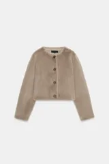 Chaqueta corta de cuello redondo y manga larga, confeccionada en tejido sintético con acabado efecto pelo. Presenta cierre frontal con botones a tono.