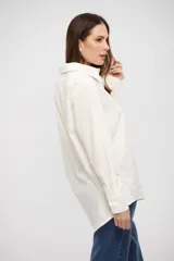Camisa de corte clásico y calce holgado, con cuello camisero, cierre frontal con botones y mangas largas con puños abotonados.