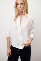 Blusa de color azul oscuro, con cuello mao y escote en V. Presenta mangas largas con puños abotonados y un corte recto y holgado.