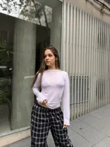 Polera de manga larga confeccionada en tela de gasa elastizada con encaje delicado y bordado a tono. Presenta un diseño ajustado al cuerpo con cuello redondo.