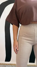 Calza de morley color beige con textura acanalada, de tiro alto y ajuste ceñido al cuerpo.