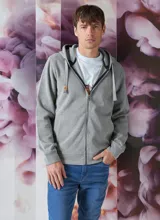 Buzo tipo hoodie con cierre frontal completo, capucha con cordones ajustables y bolsillos laterales. Confeccionado en tejido de algodón con textura jaspeada.