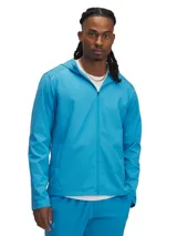 Campera deportiva Under Armour con capucha, color azul brillante, con cierre frontal completo, bolsillos laterales con cierre y detalles reflectantes. Confeccionada con tecnología UA Storm resistente al agua y al viento.