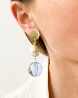 Aros colgantes con base dorada, piedra blanca con vetas marrones y esfera facetada azul.