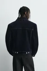 Cazadora de corte cropped confeccionada en tejido con acabado flocado efecto terciopelo. Presenta cuello solapa, cierre frontal con botones metálicos, bolsillos de plastrón con solapa en el pecho y mangas largas con puños abotonados.