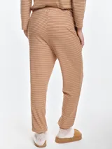 Pantalón de dormir de tela acanalada con diseño de rayas horizontales finas. Presenta cintura elastizada con cordón ajustable, bolsillos laterales y puños elásticos en los tobillos.